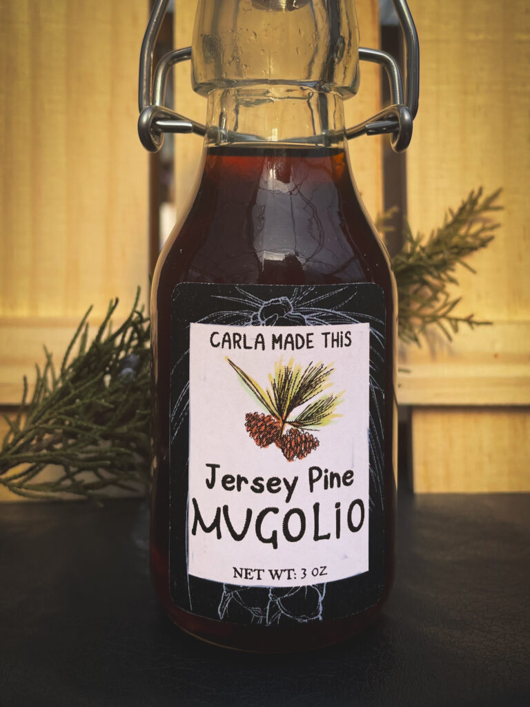 A bottle of Jersey Pine Mugolio syrup in front of a wooden background