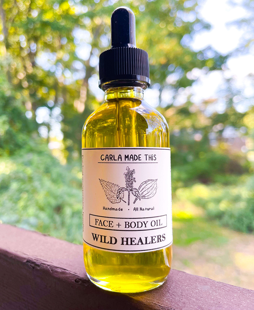 Photo of a bottle of Wild Healers Oil with the forest in the background